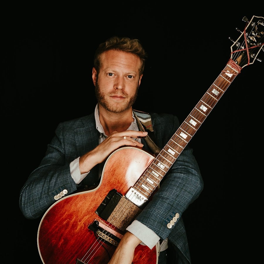 Rotem Sivan holding his archtop guitar